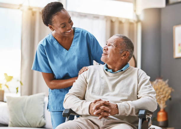 A caregiver supporting an elderly resident in a bright, comfortable room